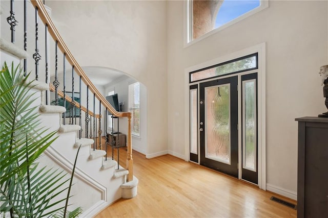 entryway featuring light hardwood / wood-style flooring and a high ceiling