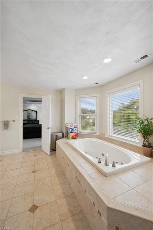 bathroom featuring tile patterned flooring and tiled bath