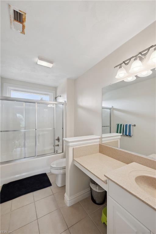 full bathroom featuring combined bath / shower with glass door, tile patterned flooring, toilet, and vanity