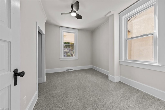 unfurnished room with ceiling fan and carpet