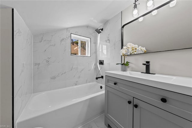 bathroom with vaulted ceiling, vanity, and tiled shower / bath combo