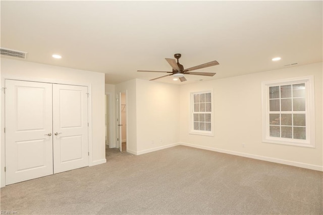 unfurnished bedroom featuring ceiling fan, light carpet, and a closet