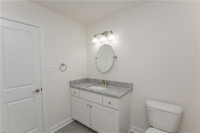 bathroom with tile patterned flooring, vanity, and toilet