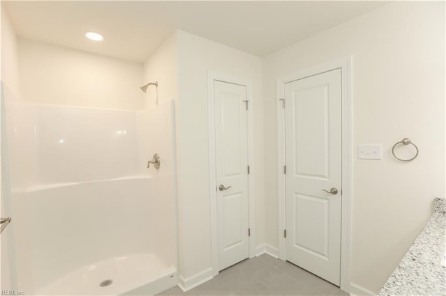 bathroom with tile patterned floors and a shower