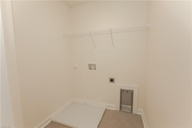 clothes washing area with hookup for an electric dryer, hookup for a washing machine, tile patterned flooring, and gas dryer hookup