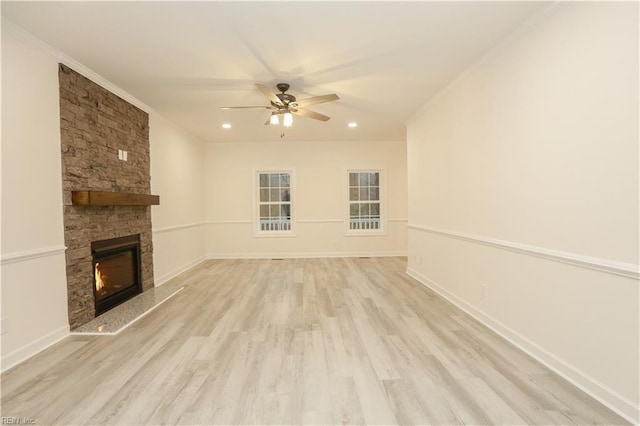 unfurnished living room featuring ceiling fan, crown molding, a fireplace, and light hardwood / wood-style flooring