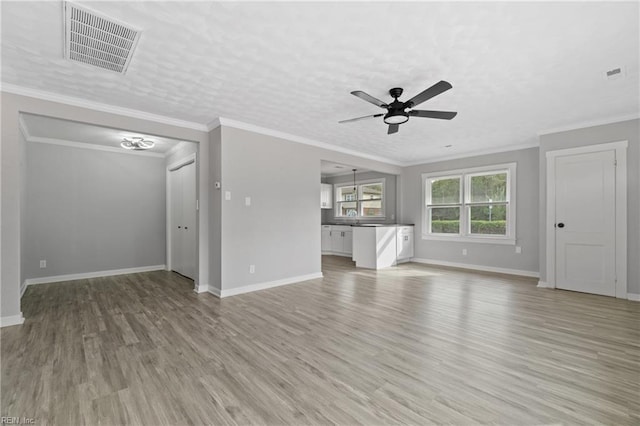 unfurnished living room with light hardwood / wood-style flooring, ornamental molding, and ceiling fan