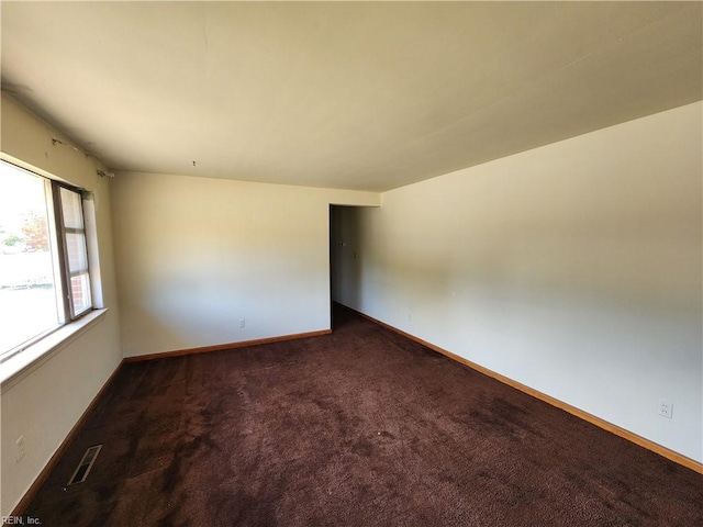 empty room featuring dark colored carpet