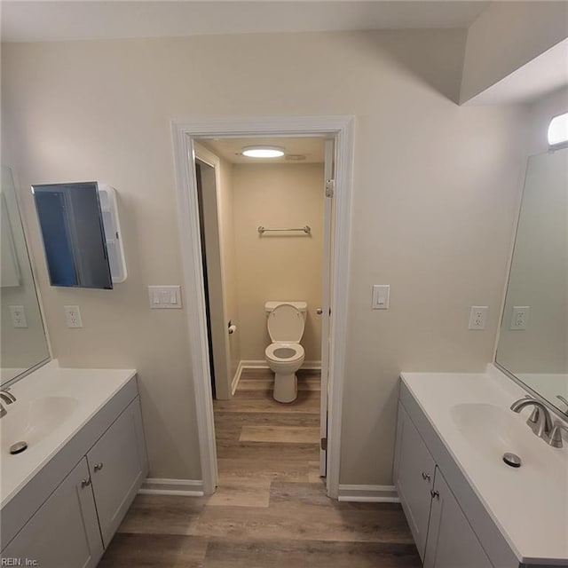 bathroom with vanity, toilet, and hardwood / wood-style flooring