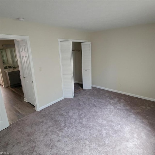 unfurnished bedroom featuring dark carpet and a closet