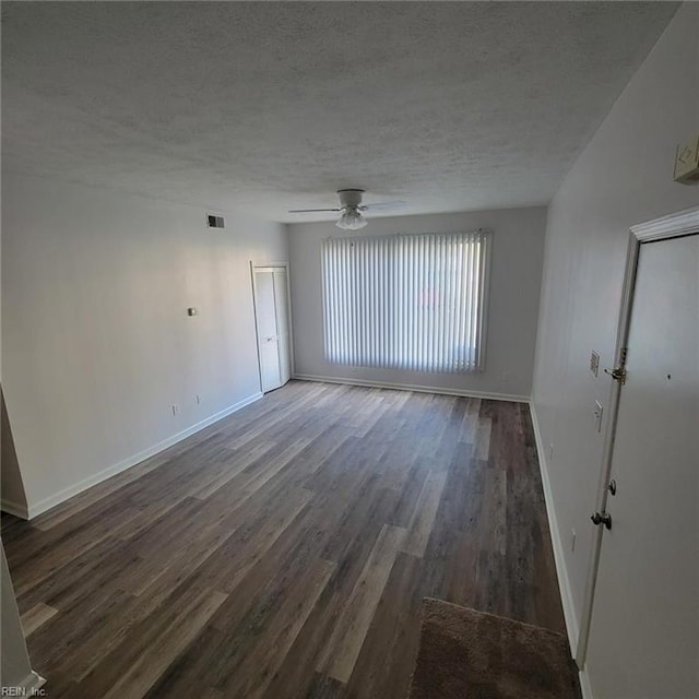 spare room featuring a textured ceiling, ceiling fan, and dark hardwood / wood-style flooring