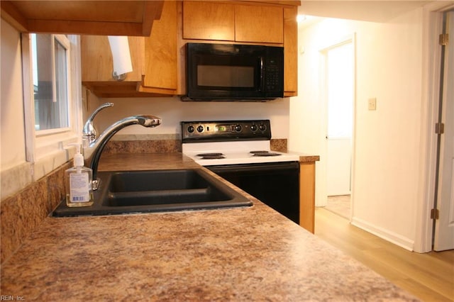 kitchen with light wood-type flooring, sink, and electric range