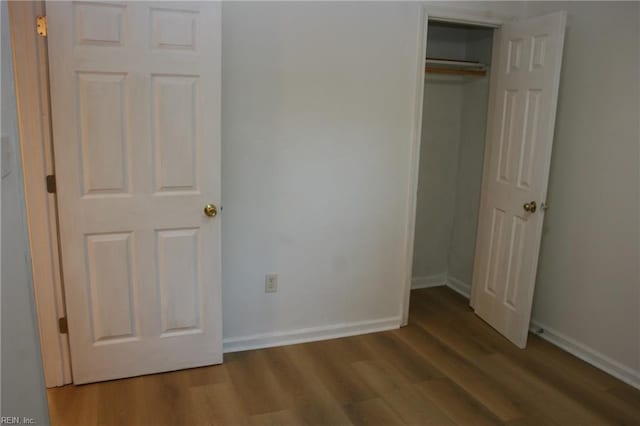 unfurnished bedroom with a closet and hardwood / wood-style floors