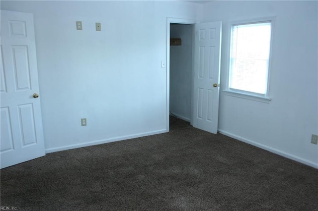 spare room with dark colored carpet