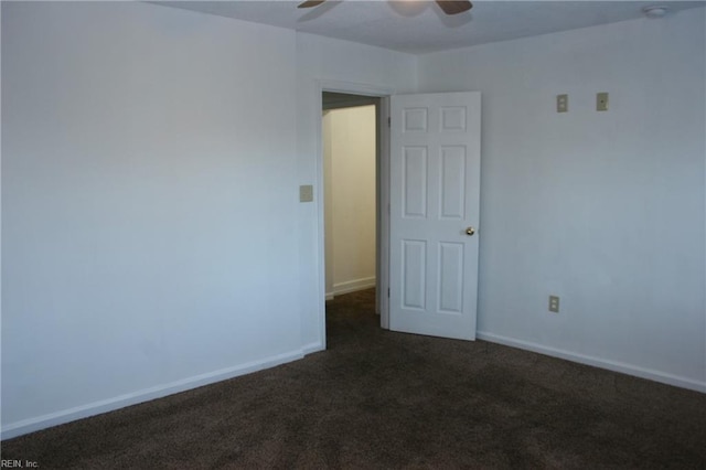 spare room with dark colored carpet and ceiling fan