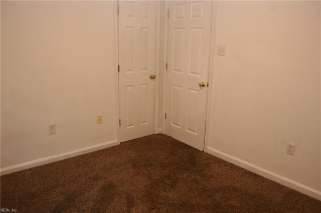 unfurnished bedroom with dark carpet