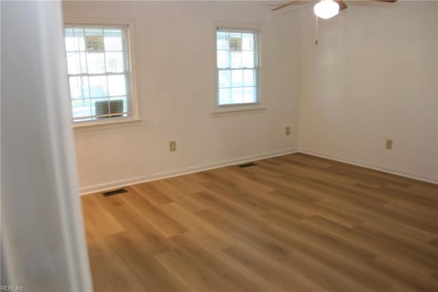 spare room with ceiling fan, a wealth of natural light, and hardwood / wood-style floors