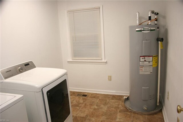 washroom with washing machine and dryer and water heater