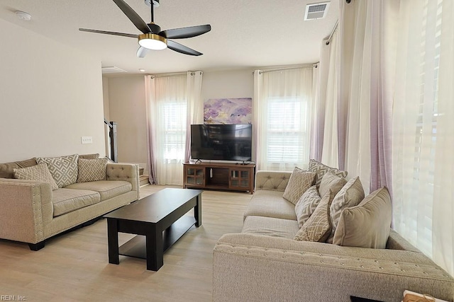 living room featuring ceiling fan and light hardwood / wood-style floors