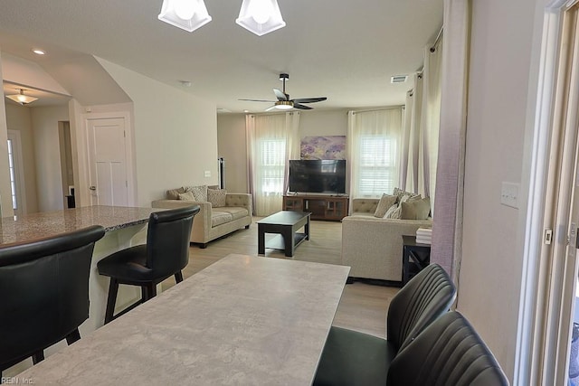 living room with light hardwood / wood-style flooring and ceiling fan