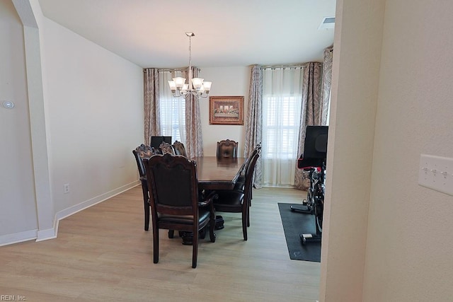 dining room featuring a notable chandelier and light wood-type flooring