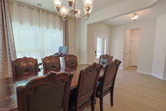 dining area featuring a chandelier and light wood-type flooring