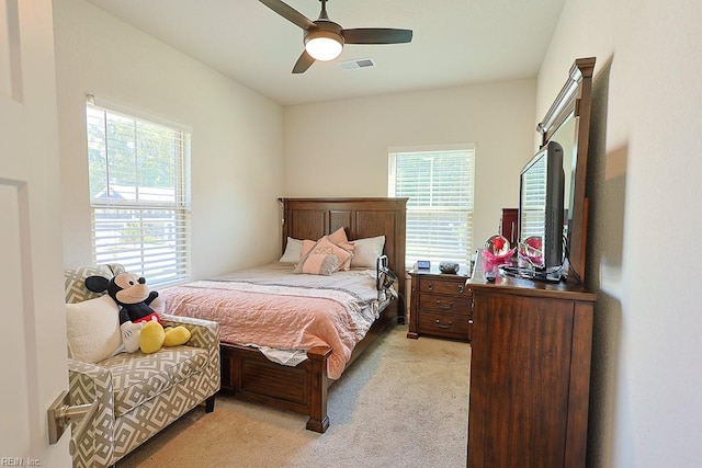 bedroom featuring light carpet, multiple windows, and ceiling fan