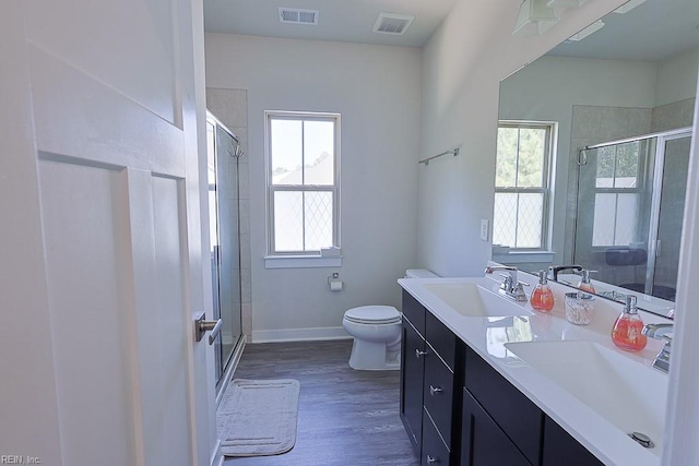 bathroom with an enclosed shower, wood-type flooring, vanity, and toilet