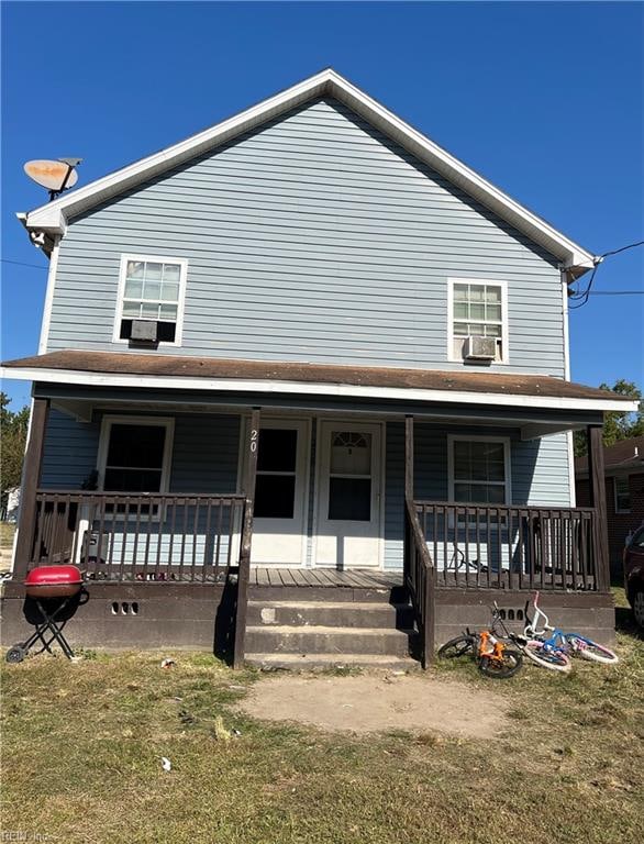 view of front facade with cooling unit, a front yard, and covered porch