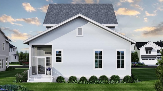 rear view of property with a yard, a sunroom, and a garage