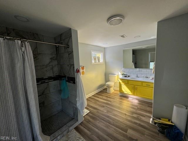 bathroom featuring hardwood / wood-style flooring, a shower with shower curtain, vanity, and toilet