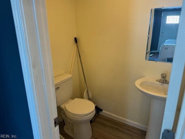 bathroom with hardwood / wood-style flooring and toilet