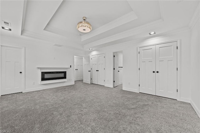 unfurnished living room with light carpet, crown molding, and a tray ceiling