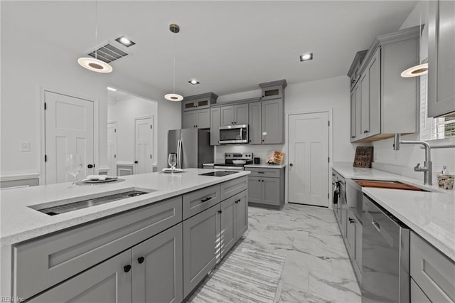 kitchen featuring decorative light fixtures, appliances with stainless steel finishes, and gray cabinetry