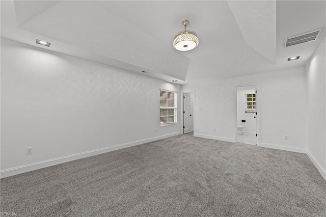 unfurnished room featuring vaulted ceiling, carpet, and a wealth of natural light