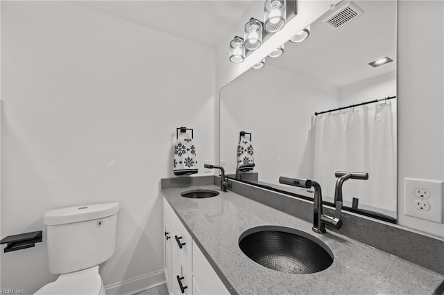 bathroom featuring vanity, toilet, and curtained shower