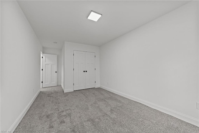 unfurnished bedroom featuring a closet and light carpet