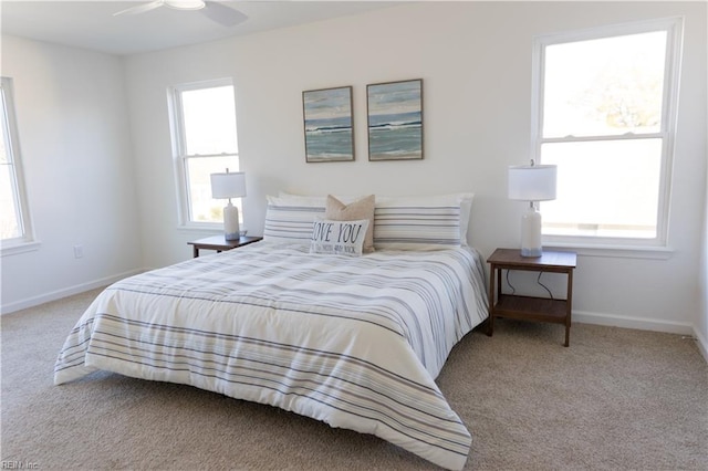 bedroom with ceiling fan, light carpet, and multiple windows