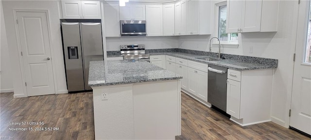 kitchen with sink, stainless steel appliances, dark wood-type flooring, a kitchen island, and white cabinets