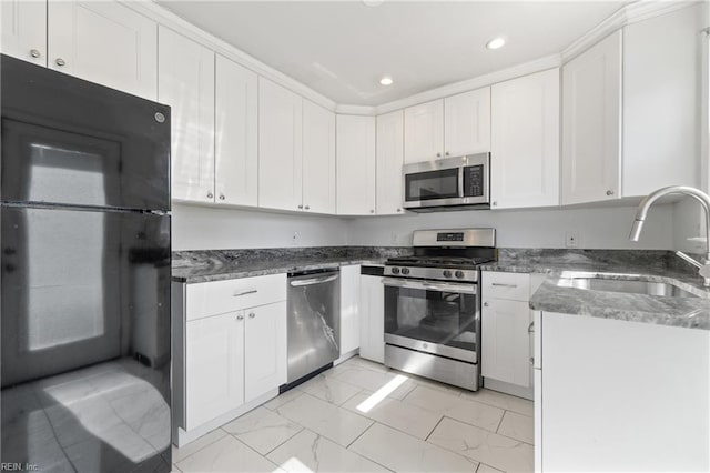 kitchen featuring appliances with stainless steel finishes, white cabinetry, and sink