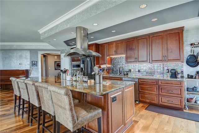 kitchen featuring light stone counters, a kitchen island with sink, light hardwood / wood-style flooring, island exhaust hood, and dishwasher