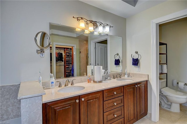full bathroom featuring tile patterned flooring, a walk in closet, a sink, and toilet