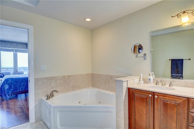 ensuite bathroom with a jetted tub, vanity, recessed lighting, tile patterned flooring, and ensuite bathroom