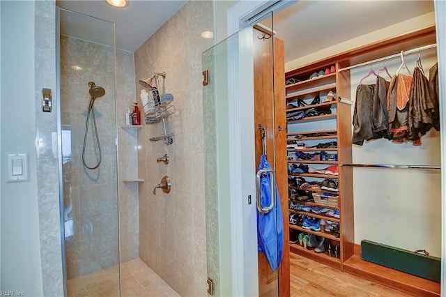 bathroom featuring wood-type flooring and a shower with shower door