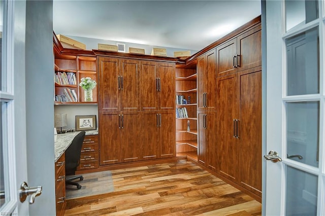 office space featuring light wood-type flooring and built in desk