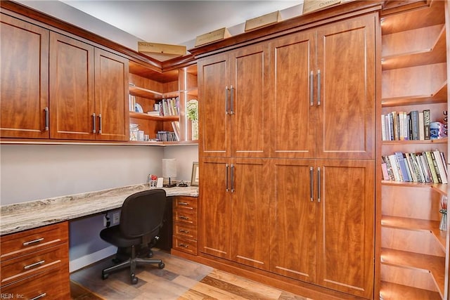 home office featuring built in desk and wood finished floors
