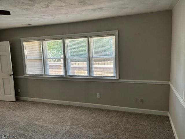 carpeted spare room with ceiling fan