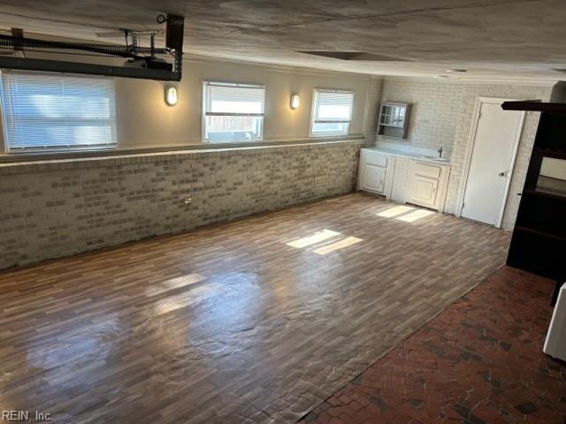 interior space featuring sink, brick wall, and ornamental molding