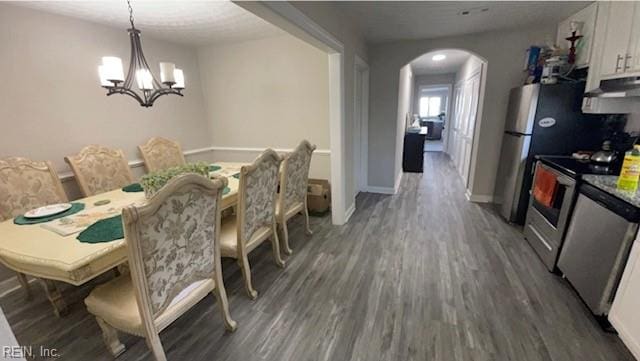 dining room with dark hardwood / wood-style floors and an inviting chandelier