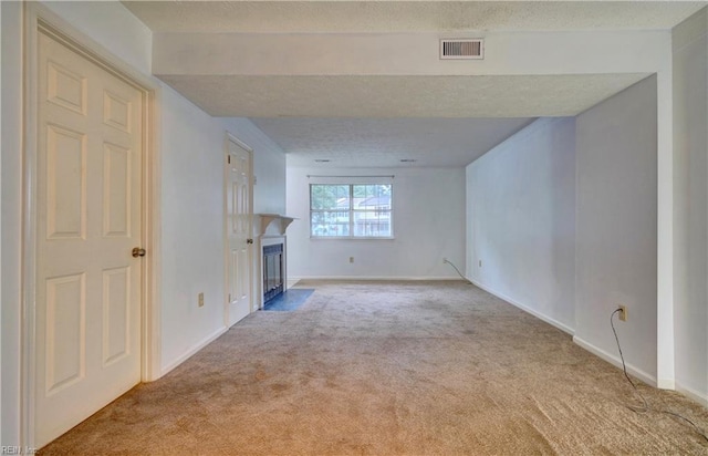 unfurnished living room featuring a textured ceiling and light carpet